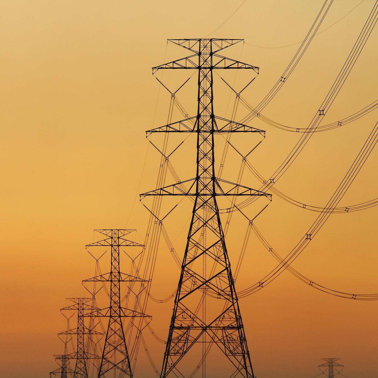 Photo of power lines silhouetted against the sunset.