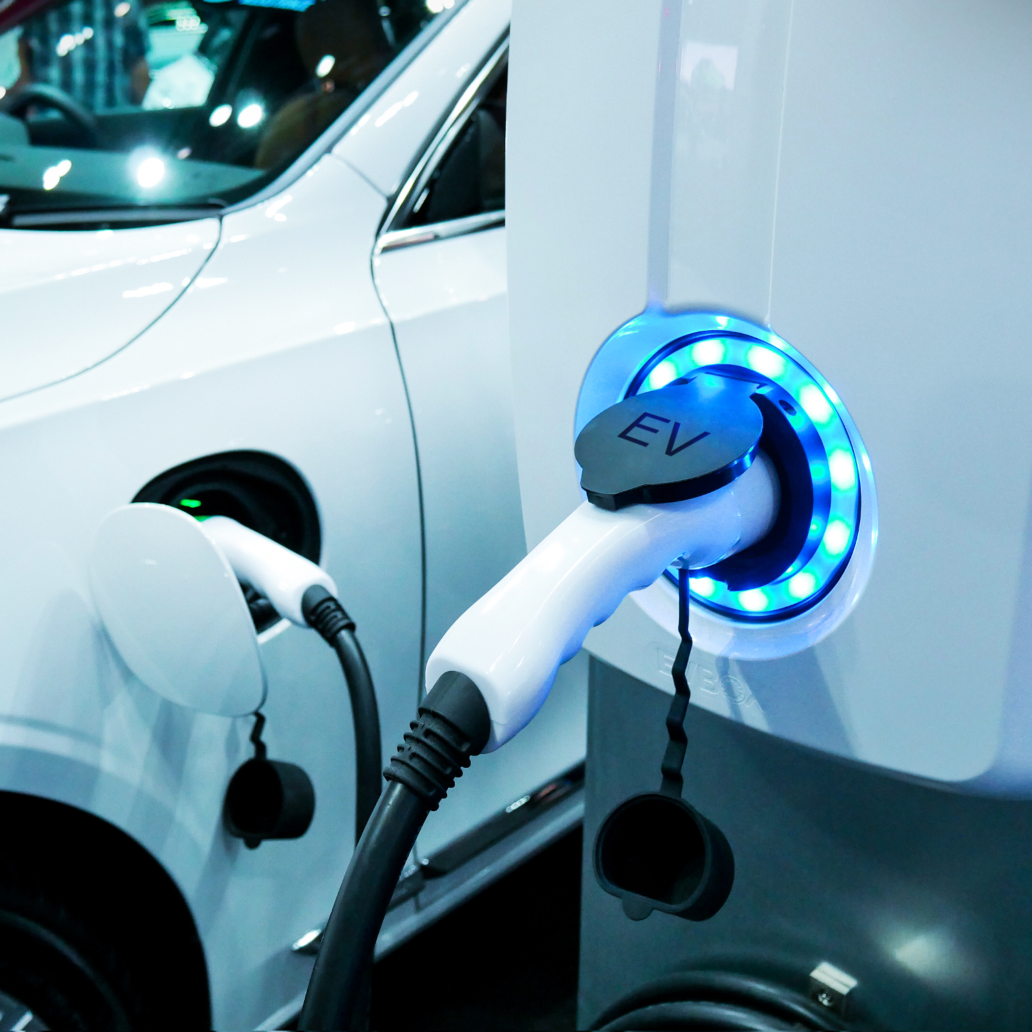 A photograph of an electric vehicle plugged into a charging station.