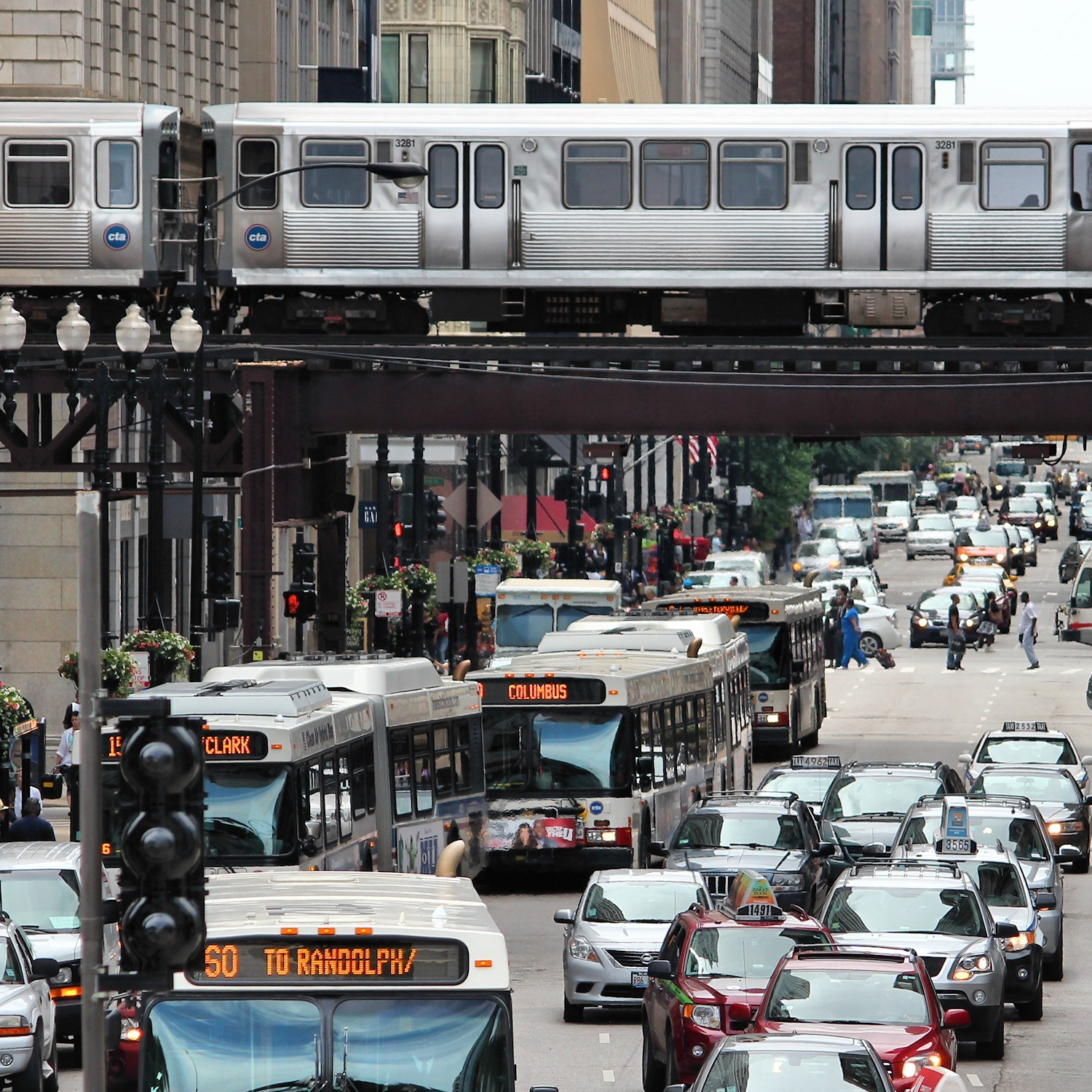 Photograph of a busy city showing cars, busses, and rail cars.