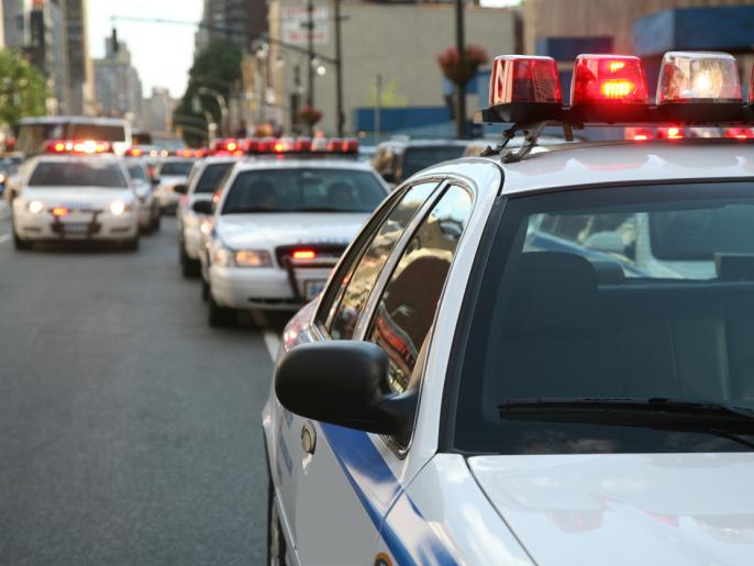 Row of police cars with flashing lights and sirens