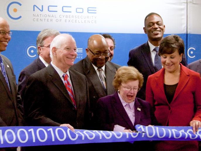 A photograph of the ribbon being cut during the ribbon-cutting ceremony at the National Cybersecurity Center of Excellence.