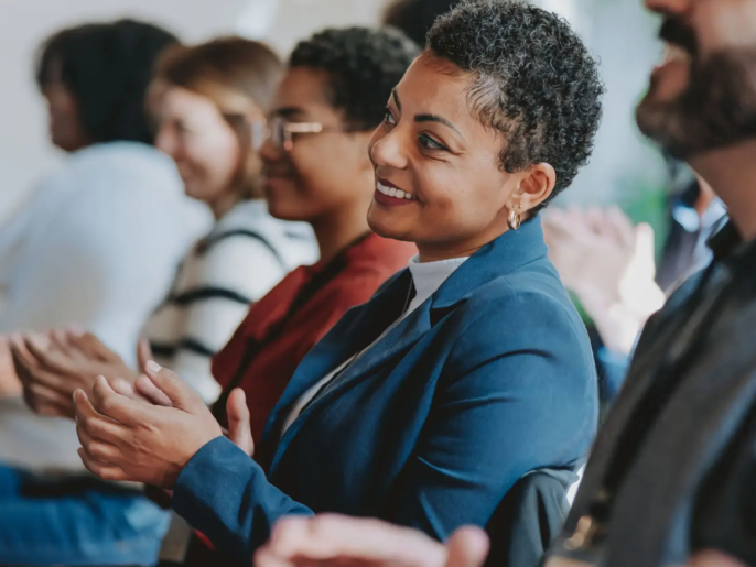 People clapping during a presentation.
