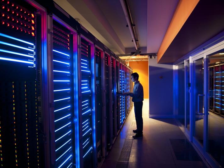 Modern interior of server room in datacenter. IT Engineer in Action Configuring Servers