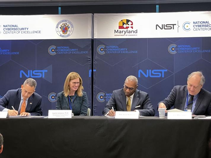 Photograph of partners with NIST's National Cybersecurity Center of Excellence signing the agreement to renew partnerships with the State of Maryland and Montgomery County.