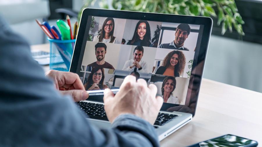 Employee speaking on video call with colleagues on online briefing with laptop at home