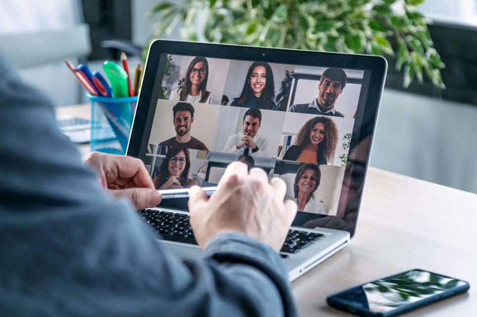 Employee speaking on video call with colleagues on online briefing with laptop at home